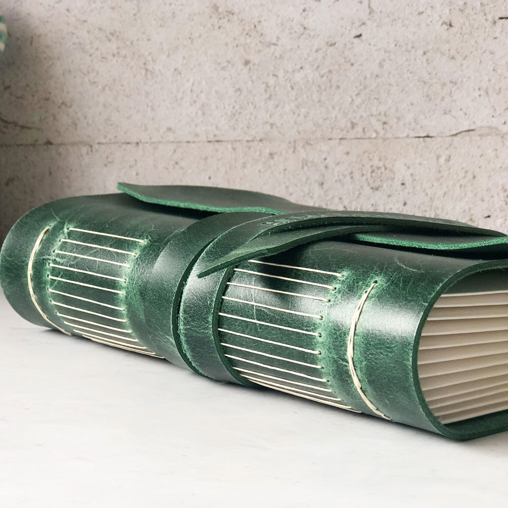 Green leather-bound book with visible natural colour stitching