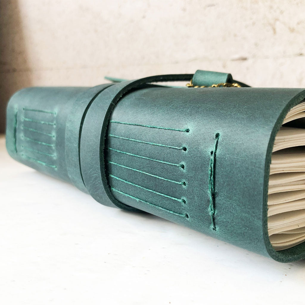 Green leather-bound notebook side view