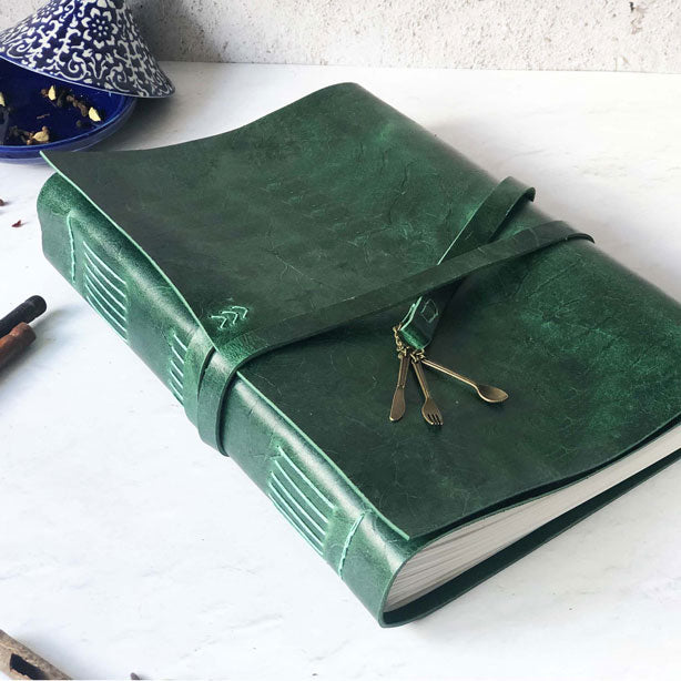 A4-sized recipe book with a green leather cover and a cutlery charm detail