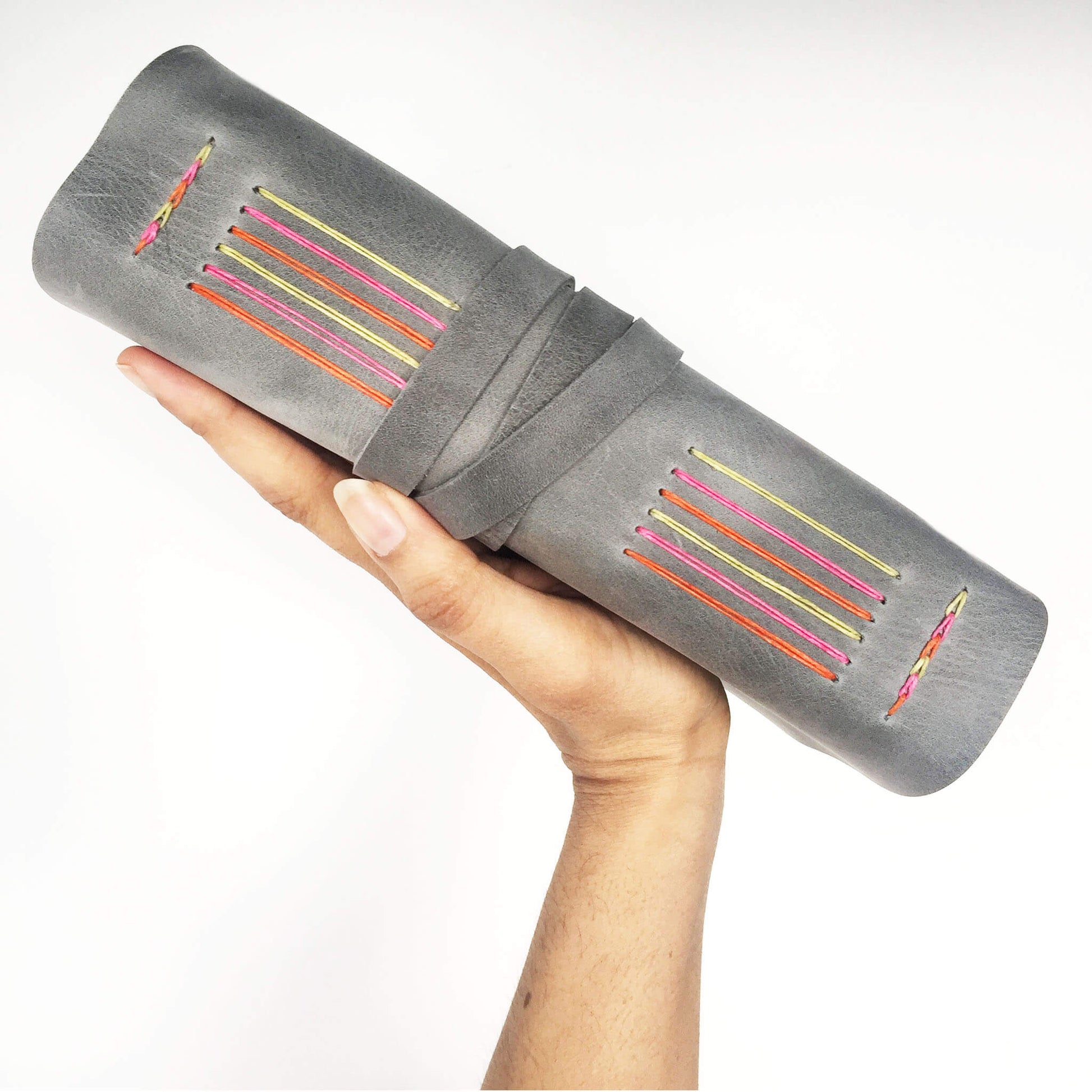 Grey travel diary with rainbow stitching, side view