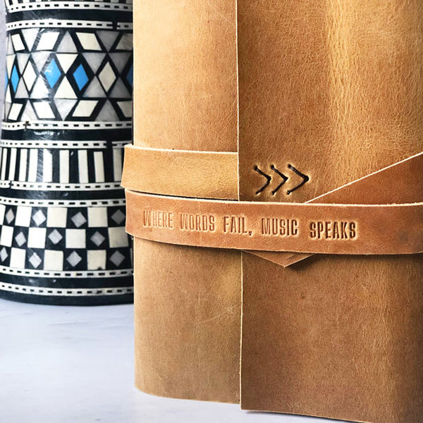 Embossed leather strap with 'Where words fail, music speaks'