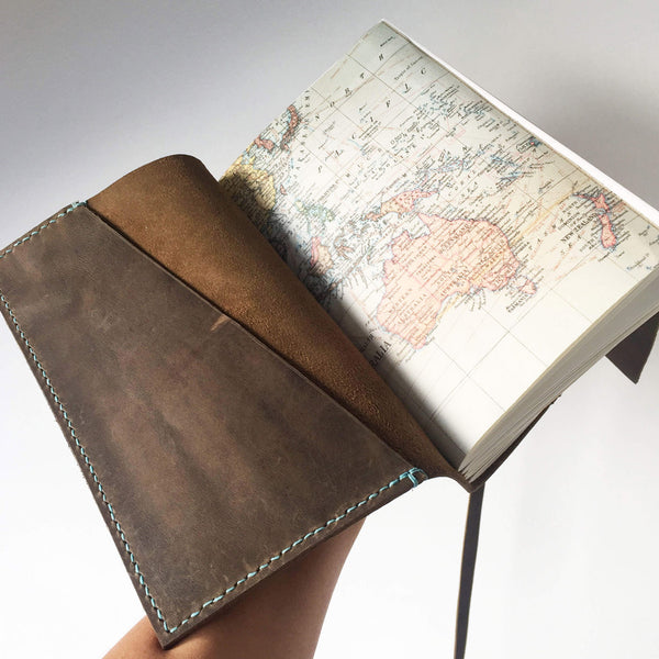 Opened view of A5 world map travel journal with saddle stitched pockets