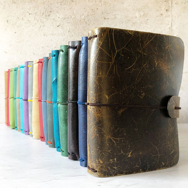 Row of leather notebook covers with elastic fastening